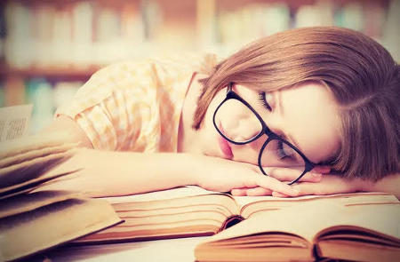 lady with glasses sleeping on book