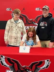 Photo of Casper College Women's Soccer team member Sierra Verplancke signing her letter of commitment to play soccer at Dakota State University. Her parents, Jodi and Jim Verplancke stand behind her.