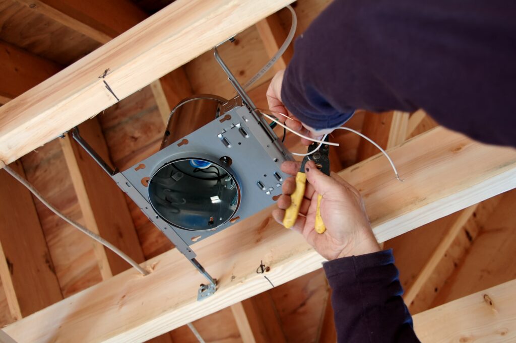 Electrician wiring a new light in a home.
