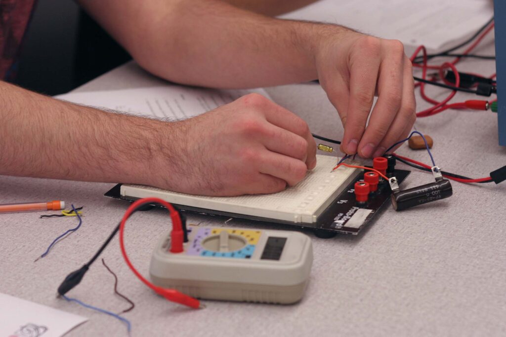 Students assemble and test an electronic circuit on a breadboard, gaining practical experience with wiring, components, and electrical measurements.