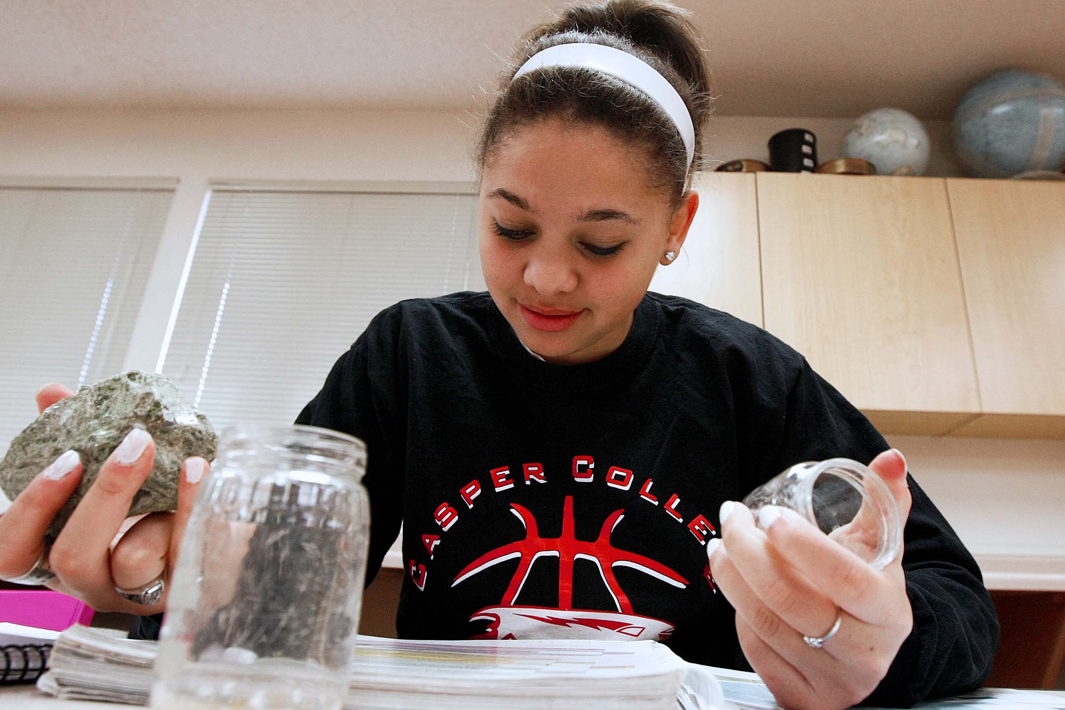 Student identifies and examines rock samples during a hands-on geology laboratory exercise.