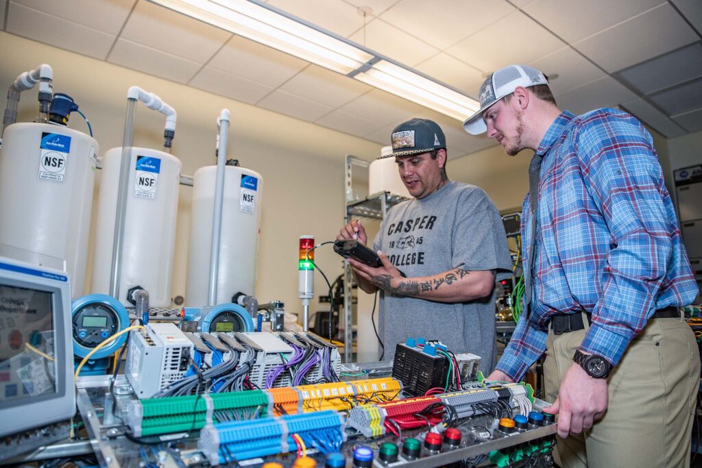 Technical Studies students collaborate on programming and troubleshooting an industrial automation system using programmable logic controllers (PLCs) and process control equipment.