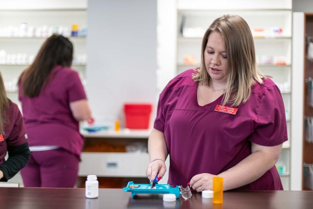 A women separates pills in her pharmacy technology class