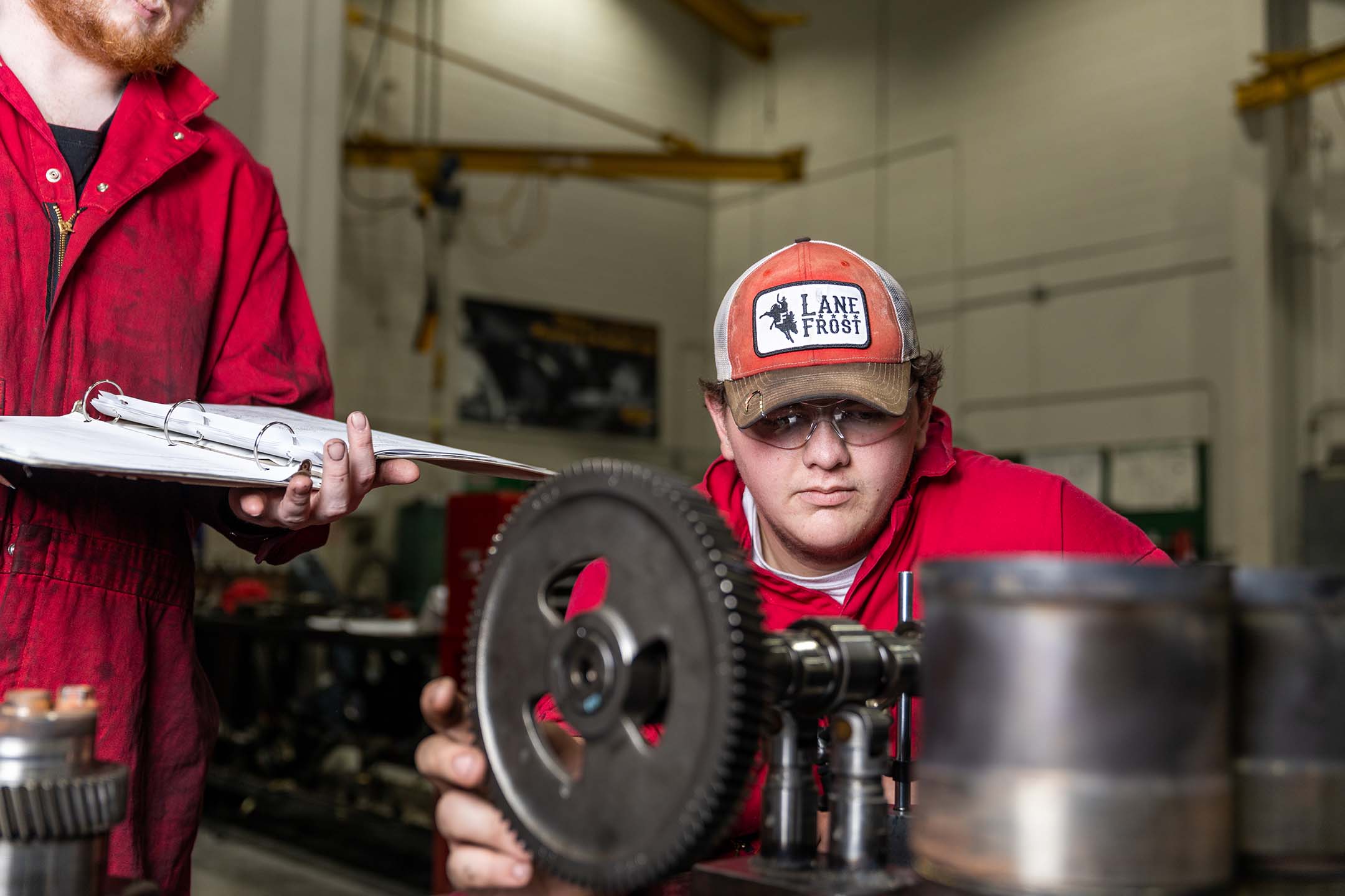 a casper college sits in front of an engine learning about Diesel power technology