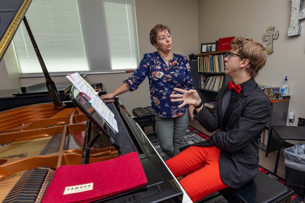 Piano instructor with a student at a piano teaching music
