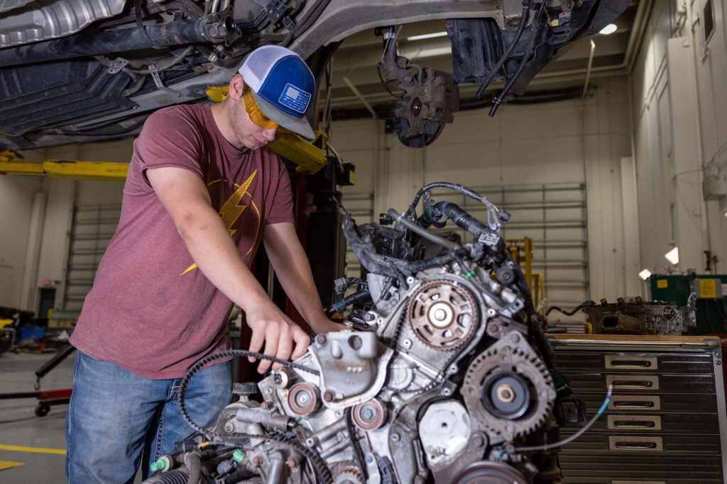 Automotive Tech class working on an engine outside of a car