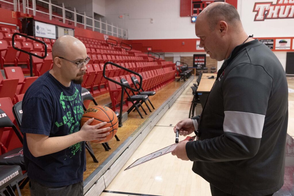 A player receiving coaching by his basketball coach.