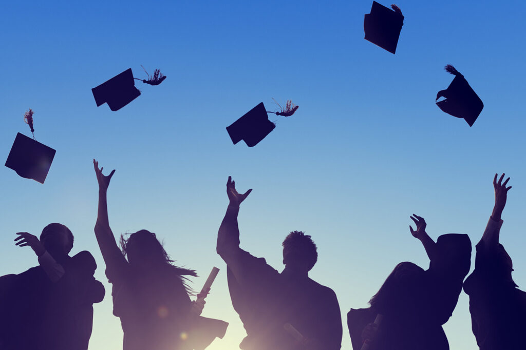 Silhouette of graduates throwing caps in the air, symbolizing success in the Casper College High School Equivalency program.