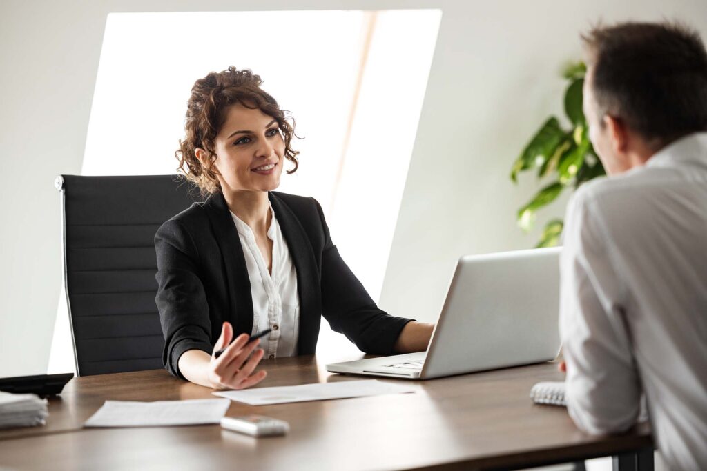 Professional woman speaking across a desk during an office meeting. Business Administratrion