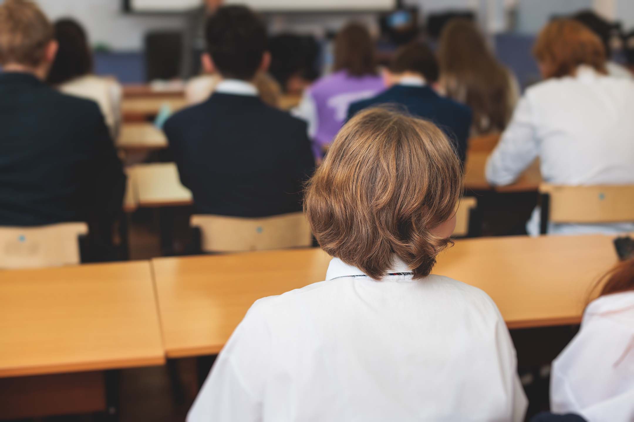 Students seated in a lecture hall listening to a presentation. history
