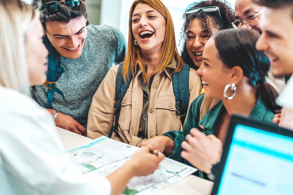 Group of young adults gathered around a table in an upbeat planning meeting. Outdoor rec