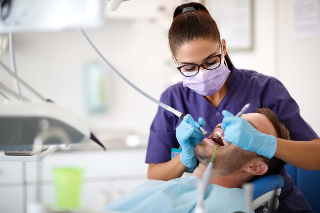 Dental professional treating a patient in a dentistry clinic.