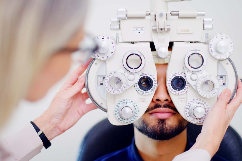 Patient looking through a phoropter during an eye exam. Optometry