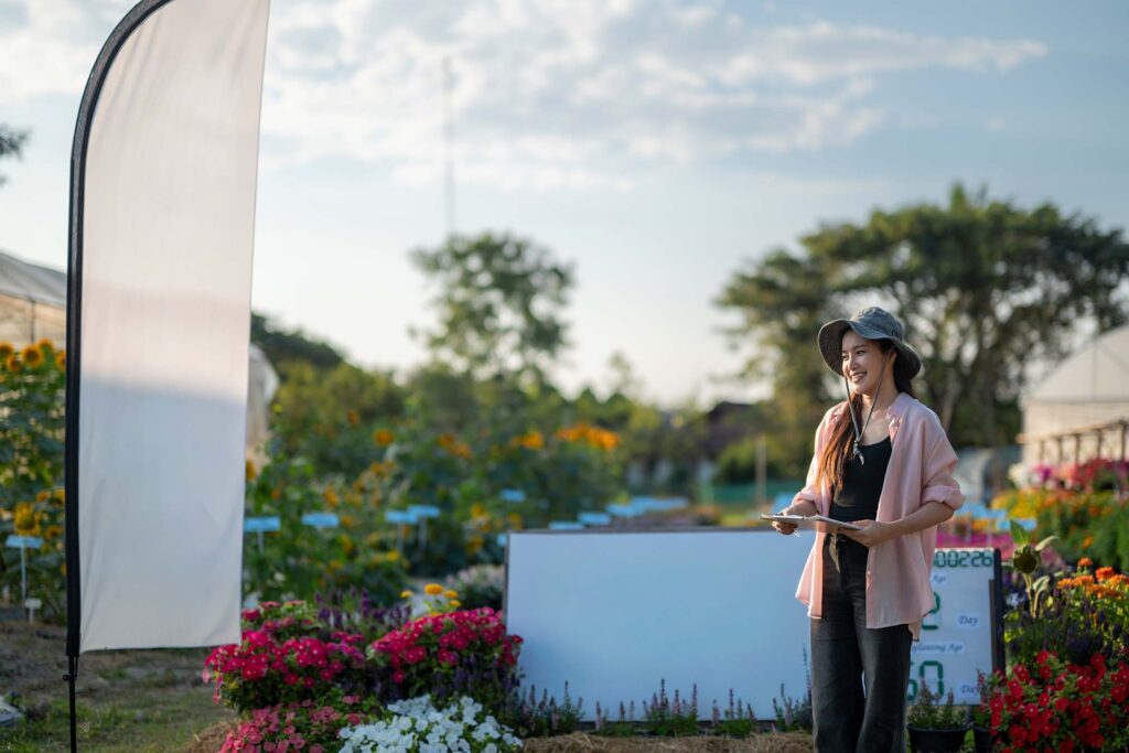Person standing outdoors near a ranch or landscaped property, looking into the distance. Agrotourism