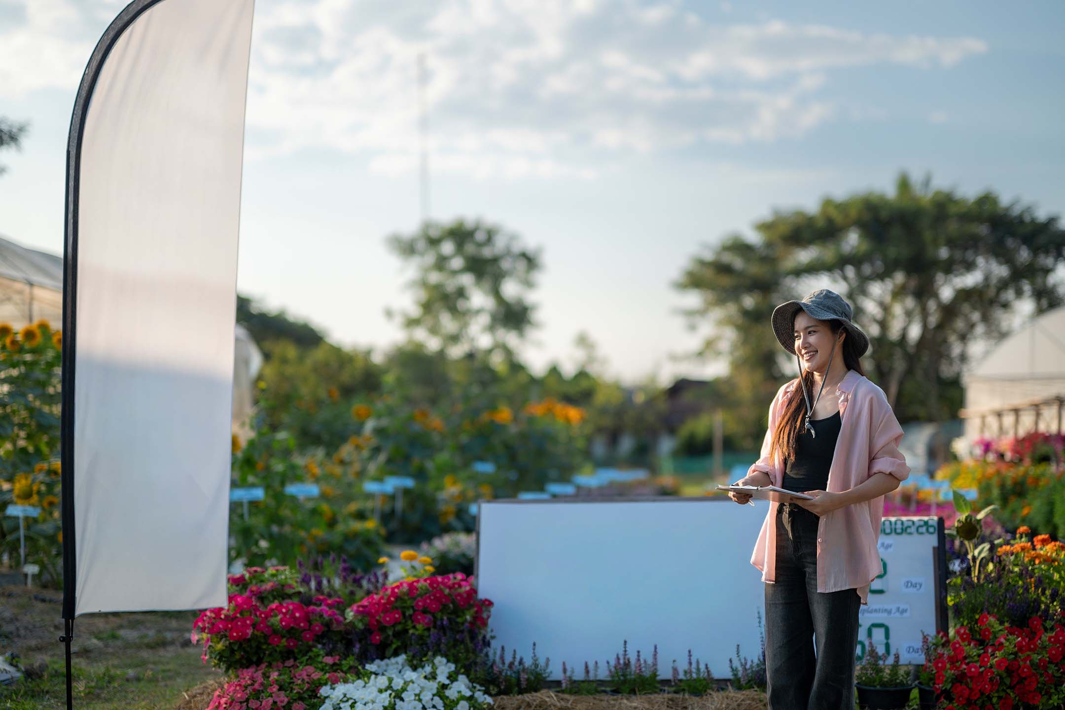 Person standing outdoors near a ranch or landscaped property, looking into the distance. Agrotourism