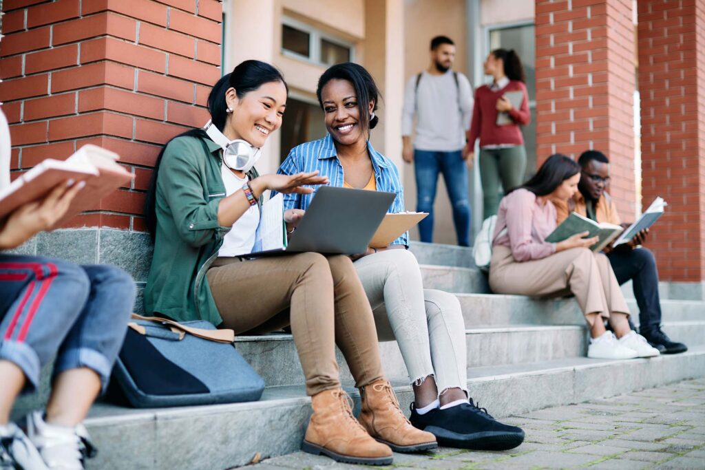 College students sitting outside a campus building and studying together.