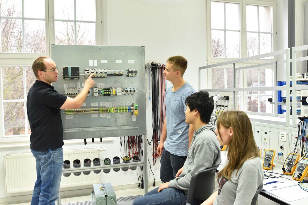 technical studies instructor demonstrating equipment to students in a technical lab.