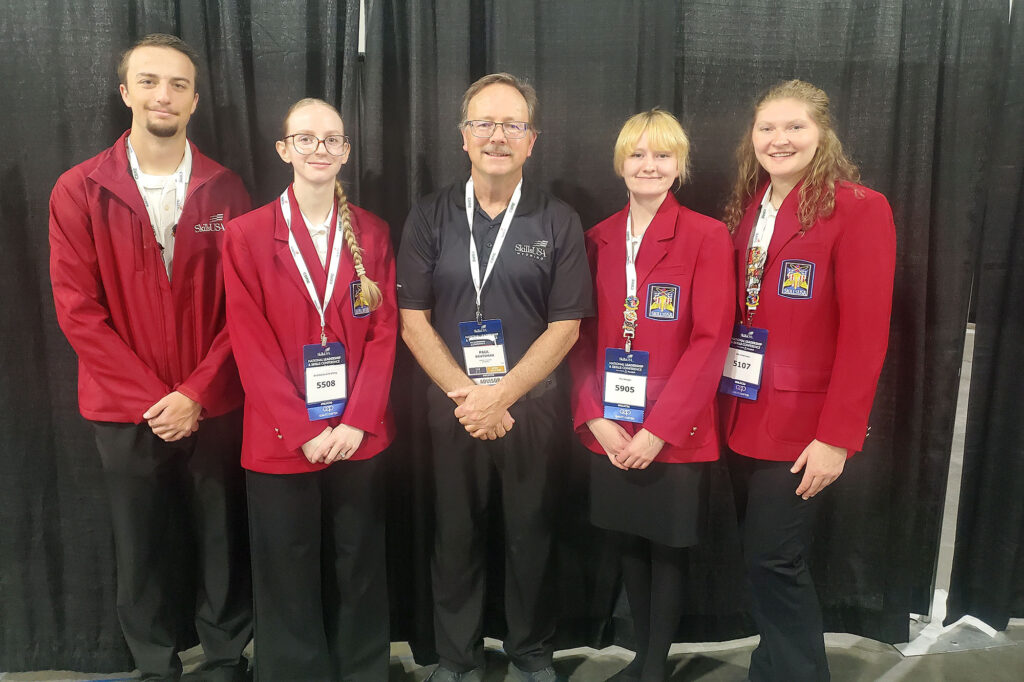 Casper College students Howard McNiven, Kimberly Bjornstad, Fionna Kerkes, and Katelyn Moeller stand with instructor Paul Brutsman in official SkillsUSA attire.