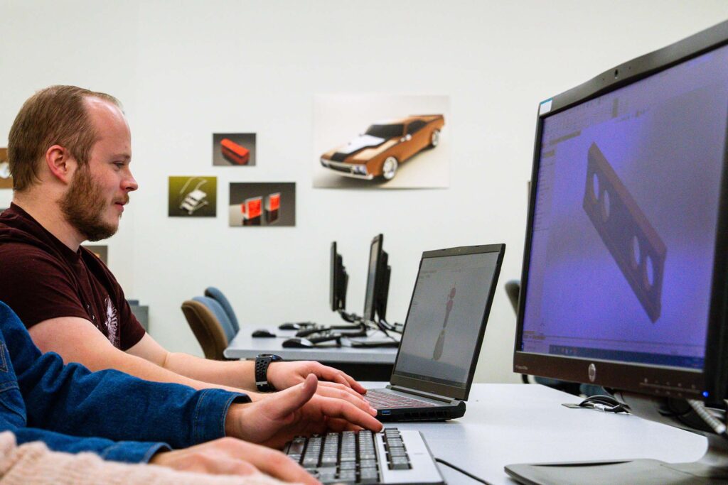 Mechanical Graphics and Design students collaborate on a 3D computer-aided design (CAD) model, developing technical drafting and engineering design skills.