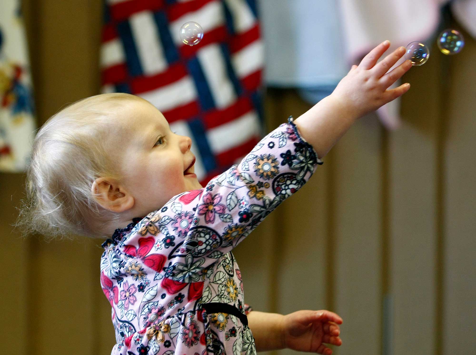 small child playing with bubbles