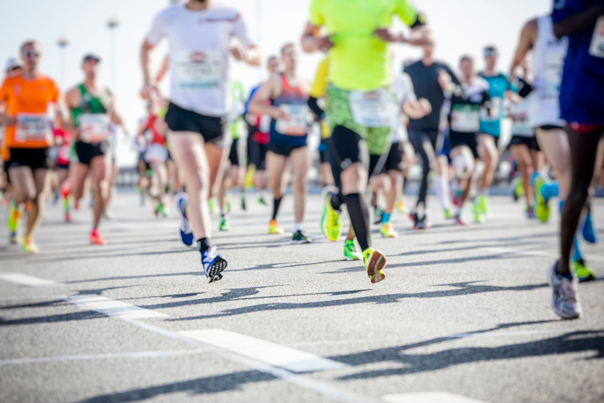 Runners' legs in motion during a road race representing the T-Bird Trek at Casper College.