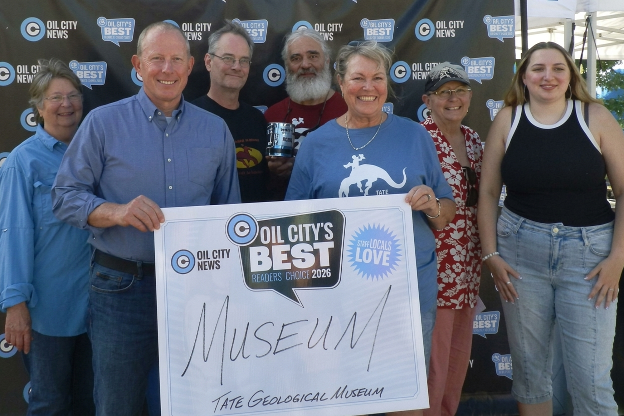 Staff and volunteers at the Tate Geological Museum holding the Oil City's Best Museum award.