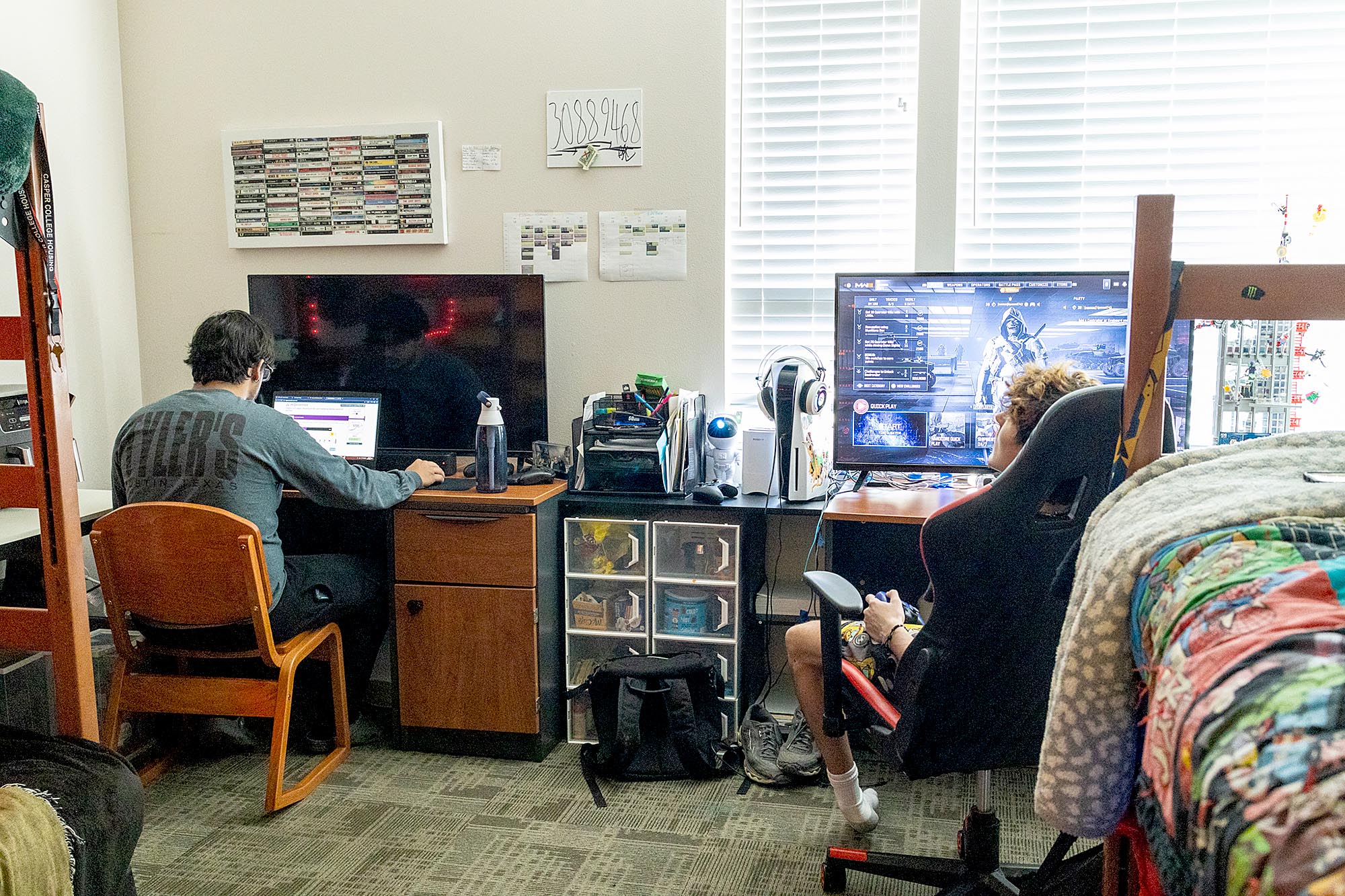 Two Casper College students managing dorm life and roommate harmony at study desks in their campus residence hall room.