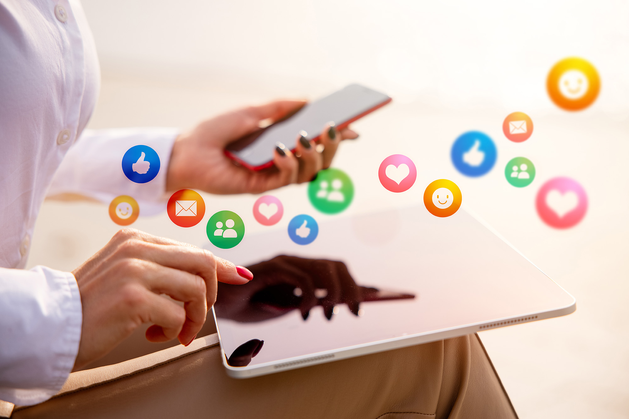 Hands holding a tablet and smartphone representing the Casper College social media certificate program.