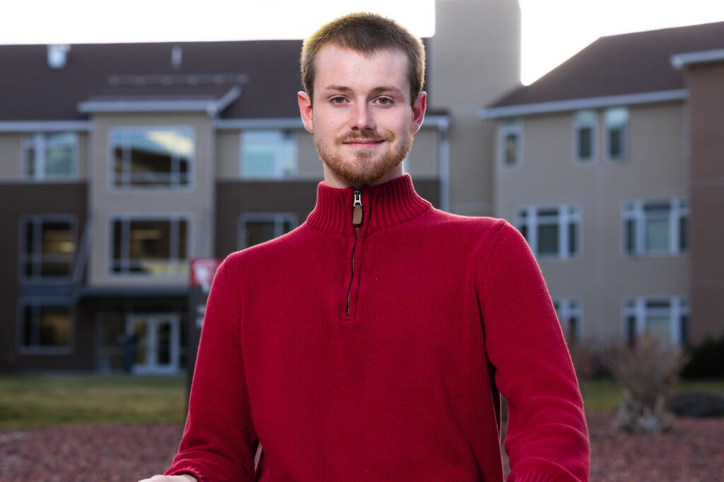 Voyager Scholarship recipient Dayton Stone standing outdoors in front of the Residence Hall at Casper College.