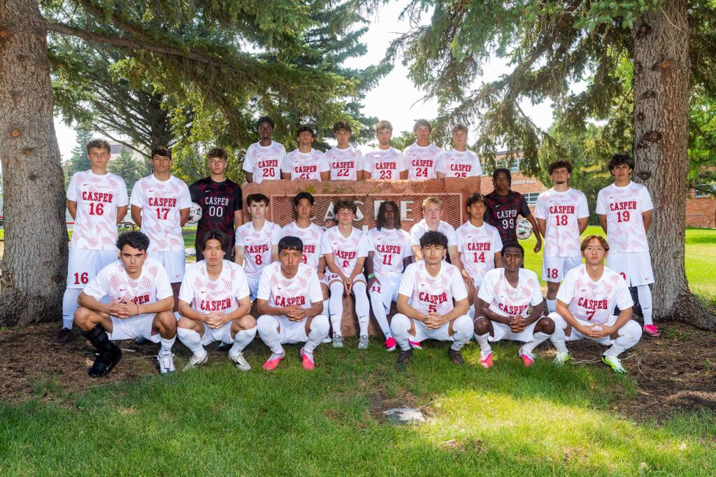 Casper College men's soccer squad posing in white uniforms outdoors ahead of the NJCAA Region 9 Men's Soccer Tournament.
