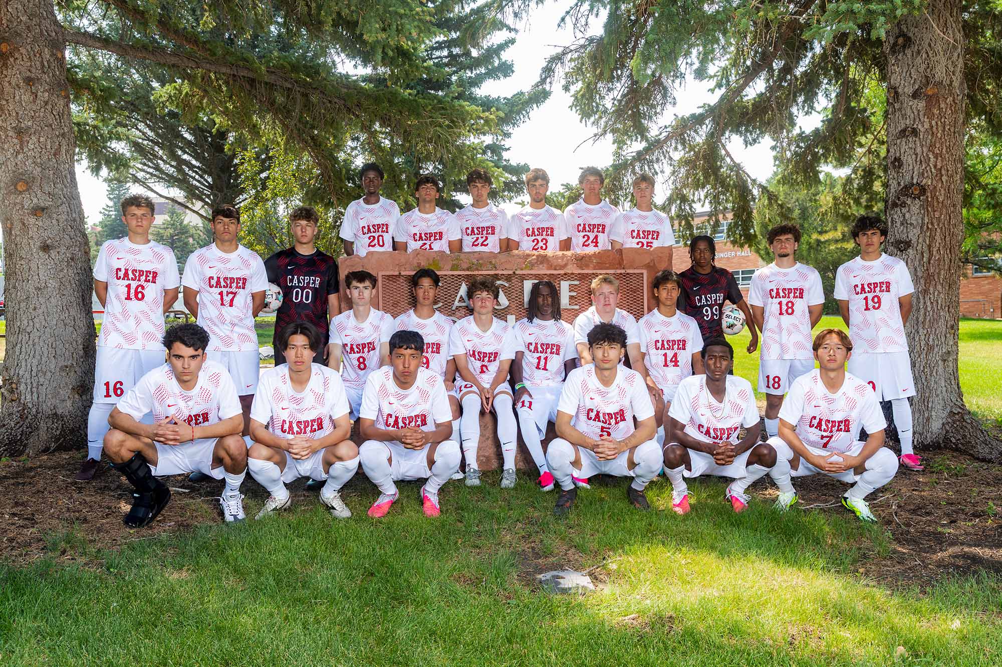 Casper College men's soccer squad posing in white uniforms outdoors ahead of the NJCAA Region 9 Men's Soccer Tournament.